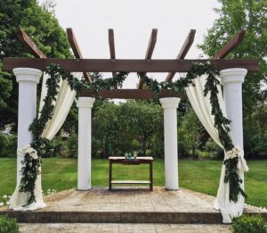 A wedding arch decorated with greenery and garlands.