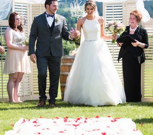 A bride and groom walk down the aisle at a vineyard wedding.
