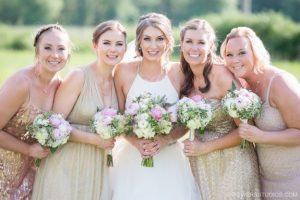 A group of bridesmaids in gold dresses posing for a photo.