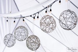 A string of wire balls hanging from a tent.