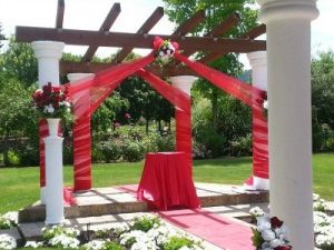 A wedding ceremony set up with red and white decorations.