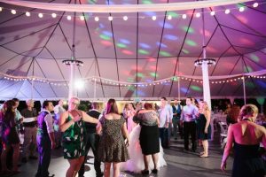 A group of people dancing in a tent.