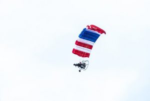 A person parachuting with an american flag in the sky.