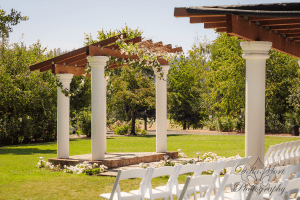 A white wedding ceremony set up in a grassy area.