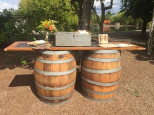A wooden table with two wine barrels on it.