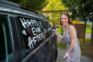 A woman writing a note on the car’s window