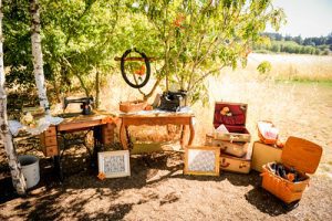 A table with a sewing machine and other items on it.
