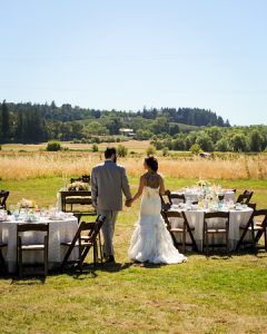 The newlyweds walking past tables and chairs