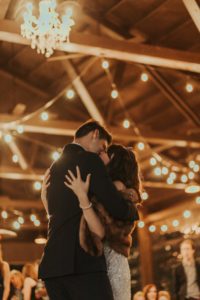 A bride and groom hugging during their first dance.
