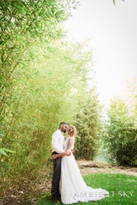 Newlyweds kissing in a bamboo clearing