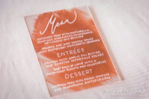 A menu card with orange and white writing on it.