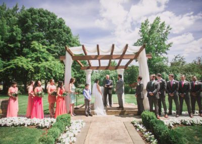 The couple before the pastor under the canopy