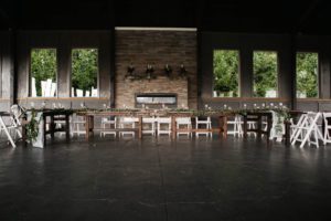 A large room with white chairs and a fireplace.