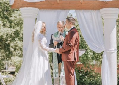 The newlyweds saying their vows before the priest