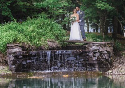 Newlyweds standing above the small waterfall