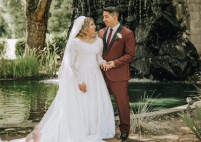 Newlyweds next to a small pond