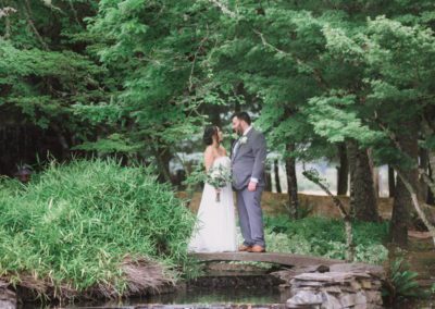 Newlyweds standing near the water’s edge