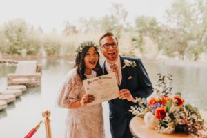 The newlyweds holding their certificate