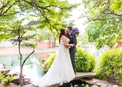 Newlyweds kissing next to the pond