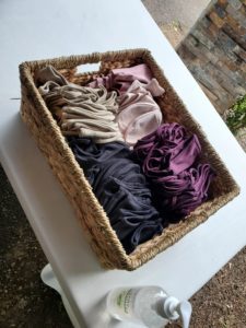 A wicker basket filled with clothes and a bottle of water.