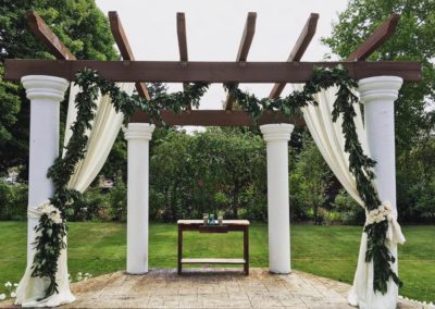 A wedding arch decorated with greenery and garlands.