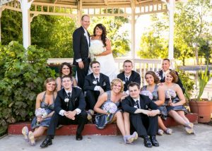 A wedding party posing in front of a gazebo.