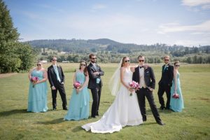 A group of bridesmaids and groomsmen posing for a photo at an Oregon outdoor wedding venue