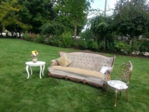 A couch set up in a grassy area.