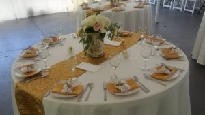 A gold table setting with place settings and napkins.