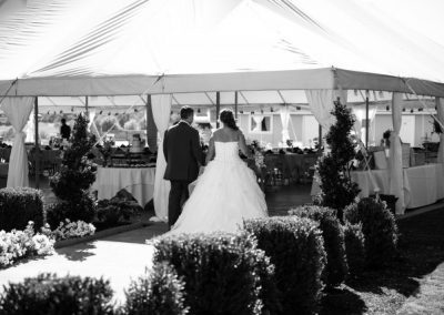 A bride and groom standing in front of a tent.