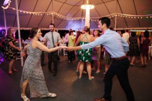 A couple dancing in a tent at a wedding reception.