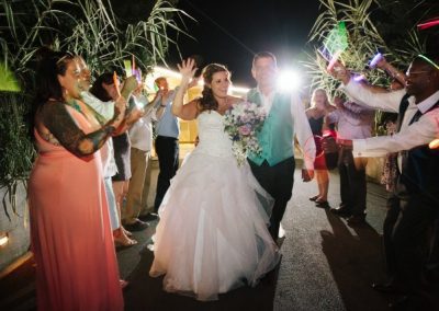 Guests holding palm fronds around the newlyweds