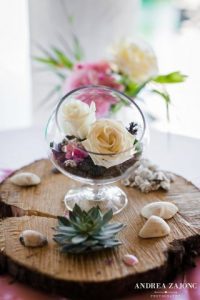Shells and flowers around a glass