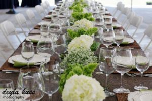 A long table set with white and green flowers.