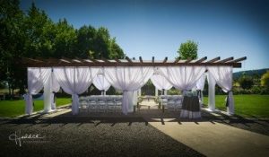 An outdoor wedding ceremony set up with white drapes.