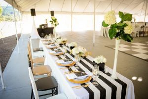 A table set up with black and white striped tablecloths.