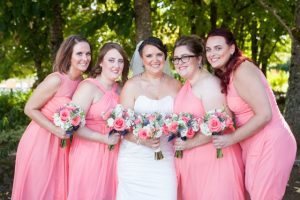 A group of bridesmaids in pink dresses posing for a photo.