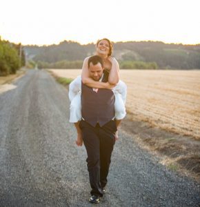 A groom carrying his bride on his back