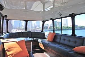 The inside of a bus with couches and a view of the city.