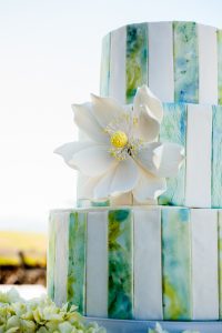 A wedding cake with a flower on top.
