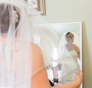 A bride looking at herself in the mirror.