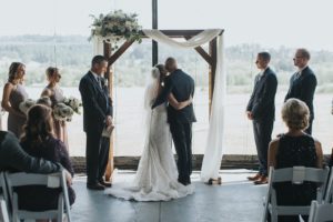 A bride and groom kiss during their wedding ceremony.