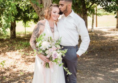 The groom kissing the bride’s head