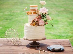 A tiered wedding cake with toppers