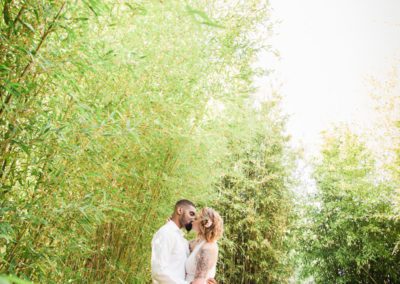 Newlyweds kissing in a bamboo clearing