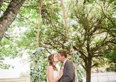 The newlyweds kiss on the swing