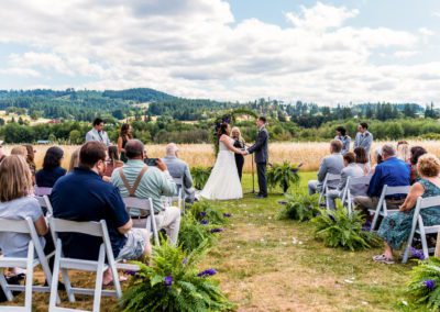 Newlyweds at the wedding arch saying their vows 