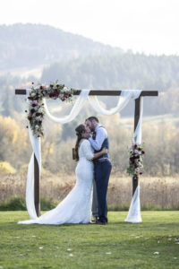 Newlyweds share a kiss at the arch