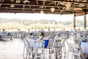 A large barn with tables and chairs set up for a wedding.