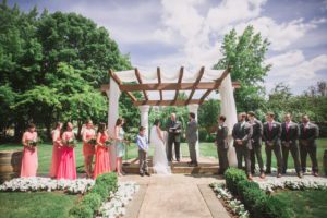 The couple before the pastor under the canopy